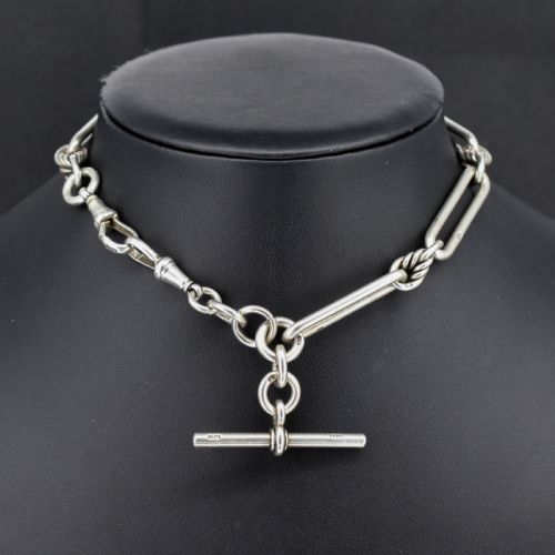 fig 1. An antique sterling silver Albert watch chain featuring elongated trombone links interleaved with twisted love knots, complete with a T-bar and swivel clip.