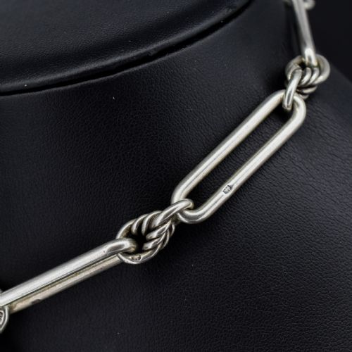 fig 3. An antique sterling silver Albert watch chain featuring elongated trombone links interleaved with twisted love knots, complete with a T-bar and swivel clip.