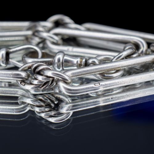 fig 4. An antique sterling silver Albert watch chain featuring elongated trombone links interleaved with twisted love knots, complete with a T-bar and swivel clip.
