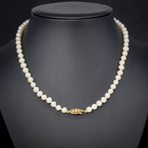 fig 1. A single strand of graduated cream pearls fitted with a detailed yellow gold filigree clasp.