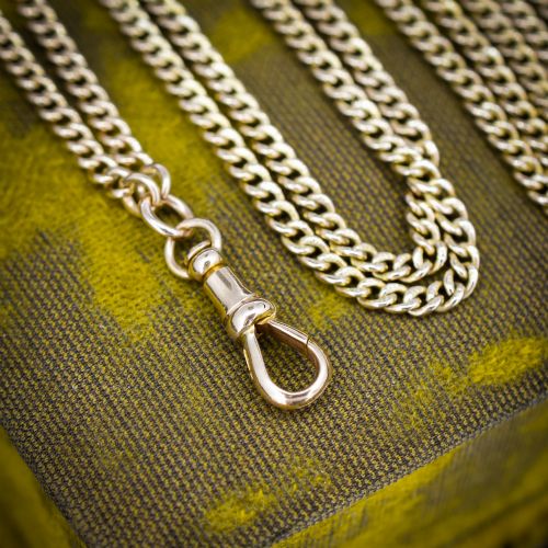 fig 3. An antique 9ct yellow gold curb link guard chain layered in multiple loops with a dog clip fastener on a black bust.