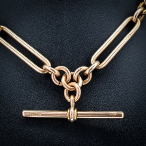 fig 1. An Edwardian 9ct gold trombone link chain necklace with a central T-bar drop and dog clip clasp.
