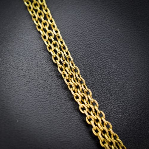fig 2. An antique Victorian 15ct yellow gold long fancy link guard chain necklace styled in multiple tiers, featuring pattern-carved gold beads and a swivel clasp hanging at the centre.