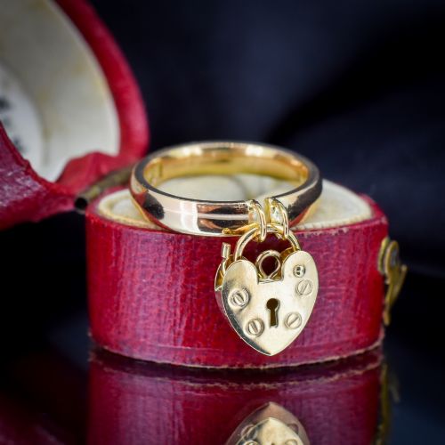 fig 1. A polished 9ct yellow gold band ring featuring a suspended heart-shaped padlock drop charm with keyhole detail.