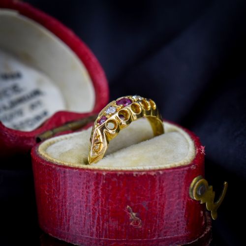 fig 1. An antique 18ct yellow gold boat ring set with three round rubies alternating with two diamonds across a carved gallery setting.