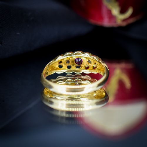 fig 3. An antique 18ct yellow gold boat ring set with three round rubies alternating with two diamonds across a carved gallery setting.
