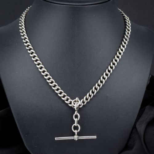 fig 1. An antique sterling silver Albert watch chain featuring heavy curb links, a central T-bar drop, and two swivel dog clip clasps.