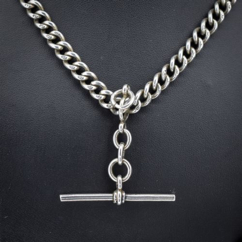 fig 2. An antique sterling silver Albert watch chain featuring heavy curb links, a central T-bar drop, and two swivel dog clip clasps.