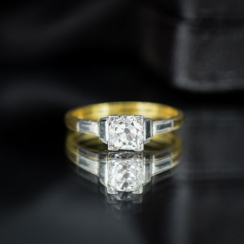 fig 2. An Art Deco engagement ring featuring a square-set central old cut diamond on an 18ct yellow gold band with white metal stepped shoulders.