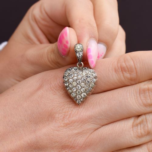 fig 2. A heart-shaped sterling silver pendant paved with hand-cut clear glass paste stones featuring an ornate bail.