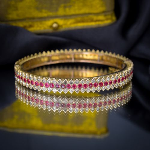 fig 2. An Art Deco hinged bangle featuring a geometric chevron pattern set with alternating rows of clear and red round-cut paste stones.