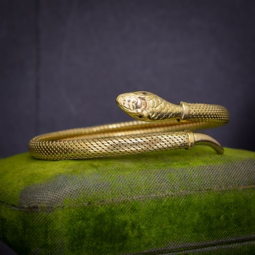 fig 1. A rolled gold coiled snake bangle bracelet featuring detailed scale engraving, a sculpted head, and a tapered tail.