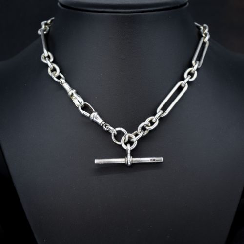 fig 1. An antique Edwardian sterling silver trombone link Albert watch chain featuring a T-bar and swivel clasp displayed on a velvet background.