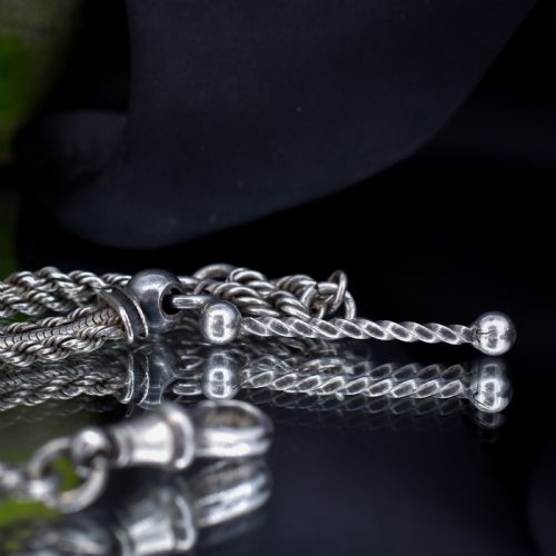 fig 2. An antique silver Albertina watch chain styled as a bracelet, featuring multi-strand rope chains, an engraved heart motif charm, a silver tassel, a T-bar, and a swivel clasp.