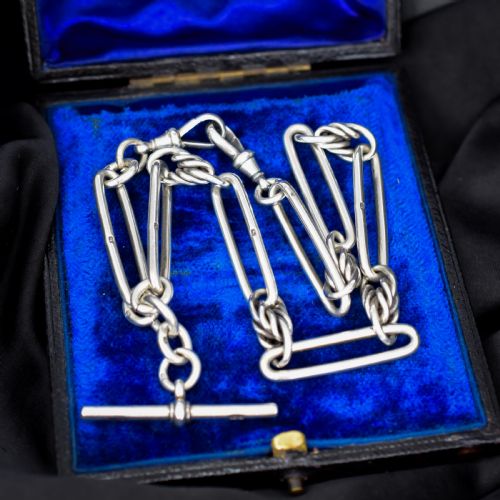 fig 1. An antique Victorian sterling silver pocket watch chain featuring elongated trombone links, twisted love knot details, a T-bar, and a swivel clip.