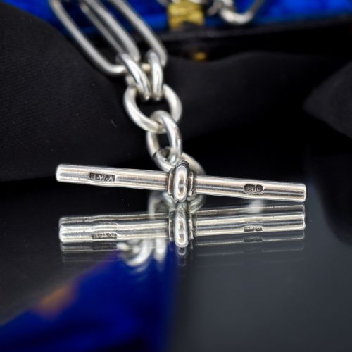 fig 2. An antique Victorian sterling silver pocket watch chain featuring elongated trombone links, twisted love knot details, a T-bar, and a swivel clip.
