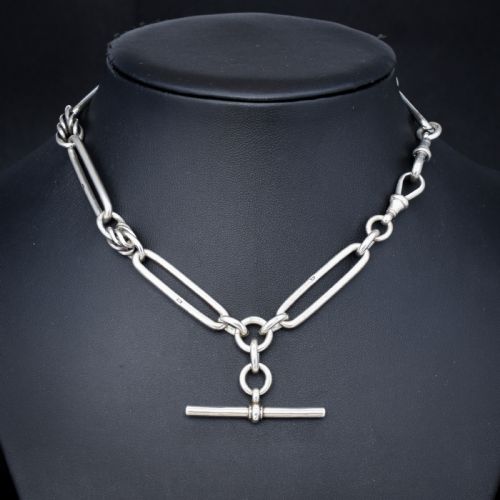 fig 3. An antique Victorian sterling silver pocket watch chain featuring elongated trombone links, twisted love knot details, a T-bar, and a swivel clip.