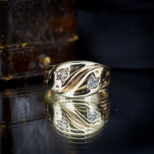 fig 2. A yellow gold band featuring two entwined snake heads, each set with a star-engraved diamond.