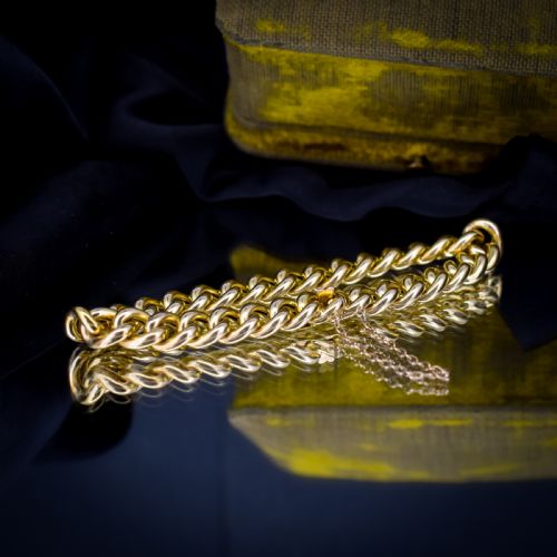 fig 1. An 18ct yellow gold curb link bracelet featuring a concealed box clasp and an attached safety chain.
