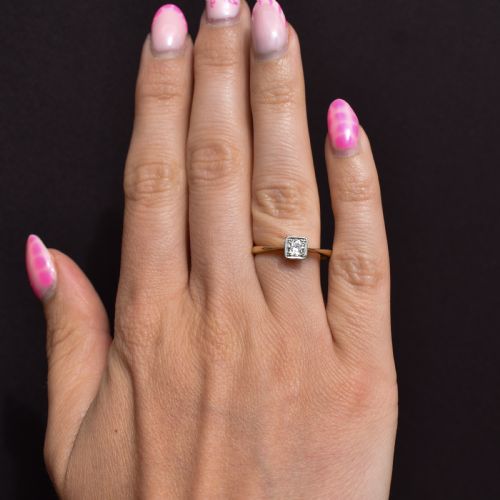 fig 2. An antique 18ct yellow gold solitaire ring holding a central round old cut diamond within a square white metal setting.