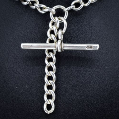 fig 1. A sterling silver curb link Albert watch chain necklace featuring a central T-bar attachment and swivel clasp on a black bust.