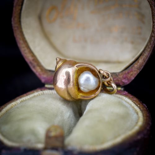 fig 1. A 9ct yellow gold seashell charm enclosing a single pearl with a top suspension loop.