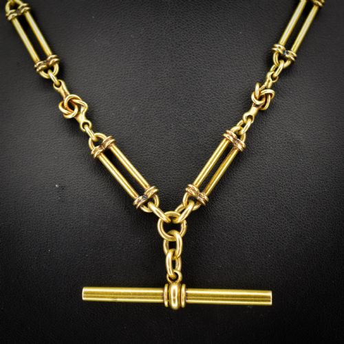 fig 2. An antique 18ct yellow gold Albert chain necklace displaying alternating trombone links and twisted love knots with a T-bar attachment.