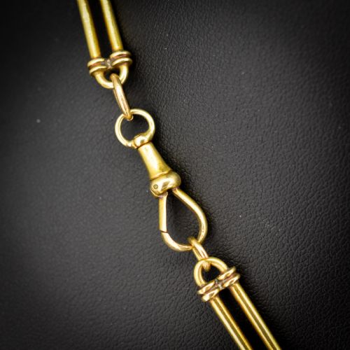 fig 3. An antique 18ct yellow gold Albert chain necklace displaying alternating trombone links and twisted love knots with a T-bar attachment.