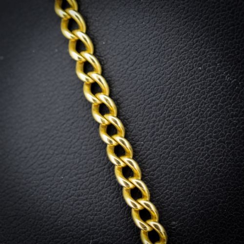 fig 2. An antique 18ct yellow gold curb link chain necklace featuring a circular bolt ring clasp on a green velvet surface.