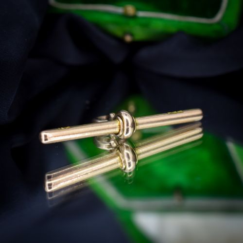 fig 2. An antique 15ct yellow gold T-bar pendant featuring a smooth crossbar, central jump rings, and stamped British hallmarks.
