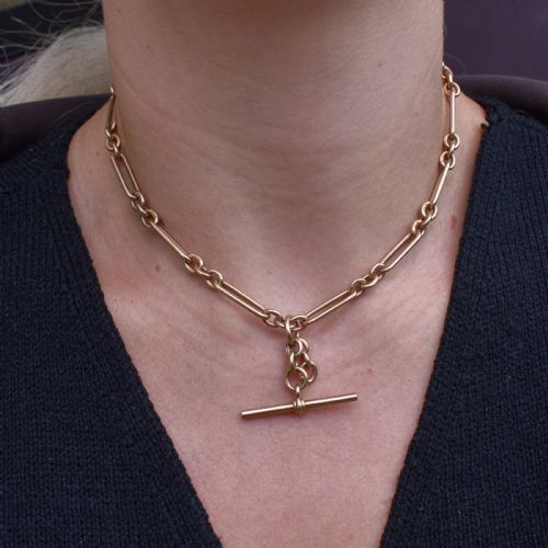 fig 1. A 9ct yellow gold Art Deco Albert watch chain featuring alternating elongated trombone links, a swivel clasp, and a T-bar.