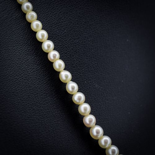 fig 2. A 16-inch single strand necklace of graduated cream pearls fitted with a gold clasp.