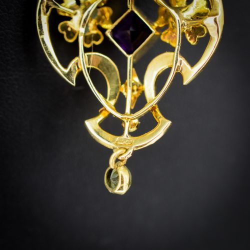 fig 4. An ornate openwork 15ct gold Edwardian pendant decorated with seed pearls, a square central amethyst, and a hanging round peridot drop.