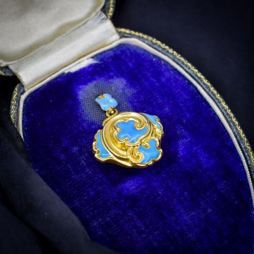 fig 1. An antique 18ct yellow gold pendant featuring swirling scrollwork inlaid with vibrant turquoise blue enamel.