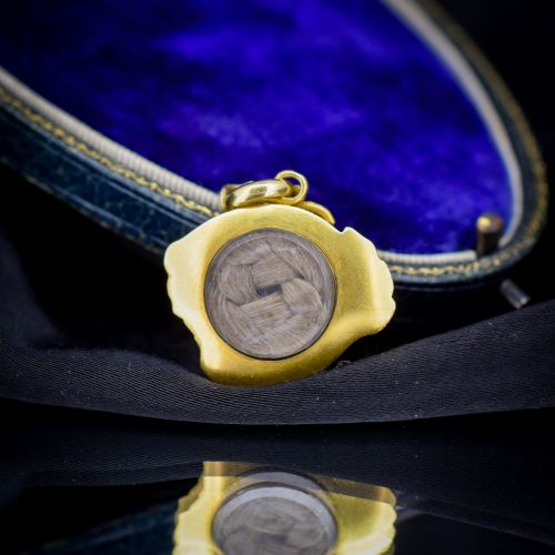 fig 2. An antique 18ct yellow gold pendant featuring swirling scrollwork inlaid with vibrant turquoise blue enamel.