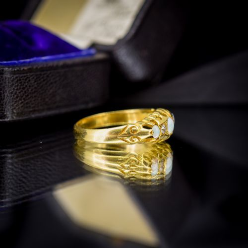 fig 1. An Edwardian 18ct yellow gold boat ring set with three cabochon natural opals and two small diamonds within a carved scrollwork gallery.