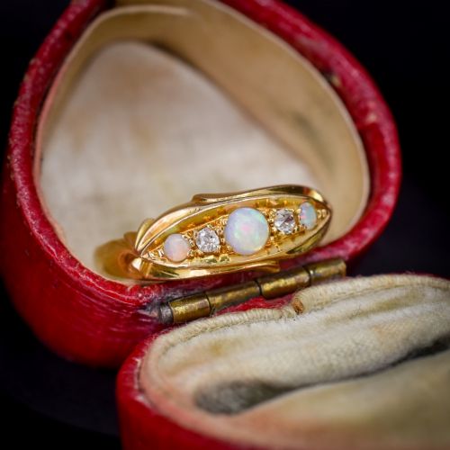 fig 1. An antique 18ct yellow gold boat setting ring featuring three cabochon opals and two small diamonds.