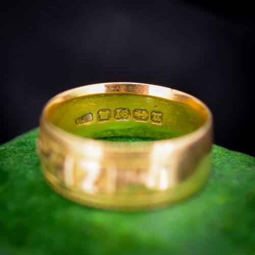 fig 2. An antique 18ct yellow gold wide band ring featuring the word MIZPAH in raised relief lettering bordered by beaded detailing.