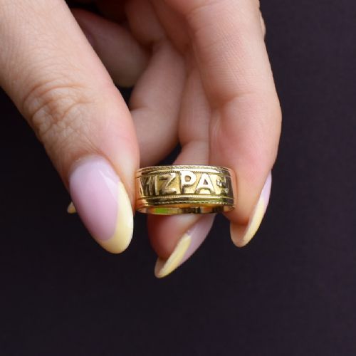An antique 18ct yellow gold wide band ring featuring the word MIZPAH in raised relief lettering bordered by beaded detailing. View IX