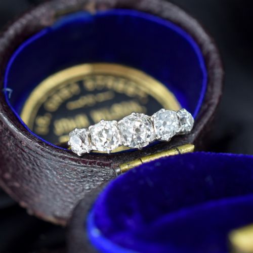 fig 2. An antique five-stone ring featuring five graduated old cut diamonds set in a row mounted on a gold band.