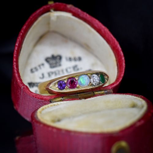 fig 1. An antique Victorian 15ct yellow gold five-stone ring flush-set with five varied round gemstones across a polished band.