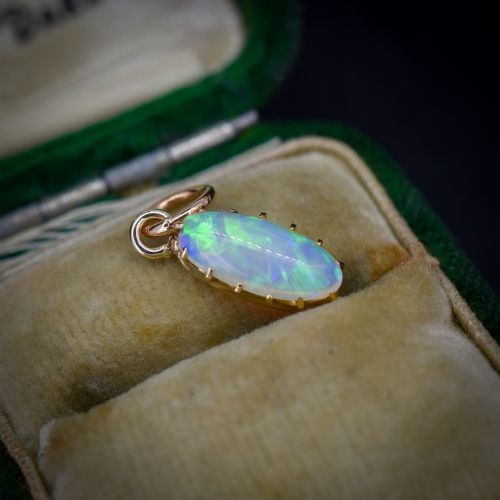 fig 2. An oval natural opal cabochon pendant held in a multi-claw yellow gold setting with an attached jump ring.