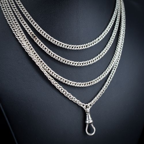 fig 1. A long sterling silver flat curb link guard chain draped in multiple tiers with a dog clip clasp at the bottom.