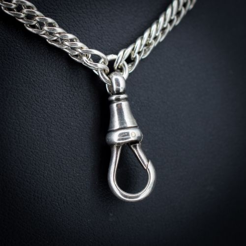 fig 2. A long sterling silver flat curb link guard chain draped in multiple tiers with a dog clip clasp at the bottom.