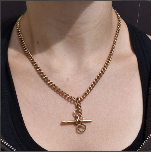 fig 1. An antique 15ct yellow gold Albert chain necklace featuring curb links, a T-bar drop, a bolt ring, and a dog clip clasp.