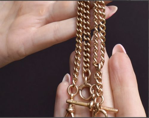 fig 2. An antique 15ct yellow gold Albert chain necklace featuring curb links, a T-bar drop, a bolt ring, and a dog clip clasp.