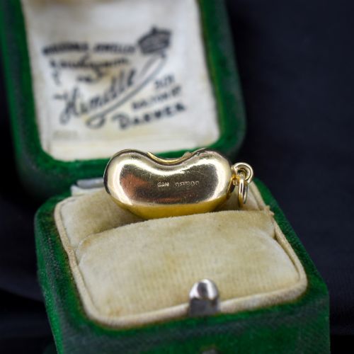 fig 1. A smooth, polished 9ct yellow gold bean-shaped charm with an attached suspension jump ring.