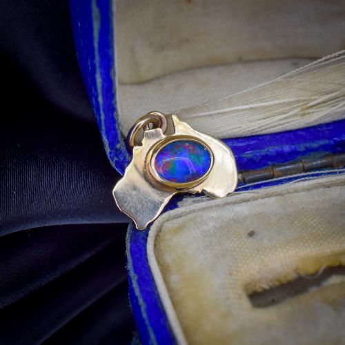 fig 1. A 9ct yellow gold pendant in the shape of Australia, featuring a central bezel-set oval black opal triplet with blue and violet play-of-colour.