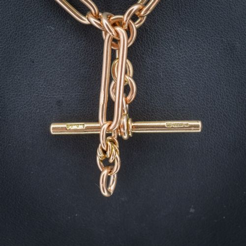 fig 1. An antique 9ct yellow gold necklace featuring elongated trombone links, twisted love knots, and a central suspended T-bar.