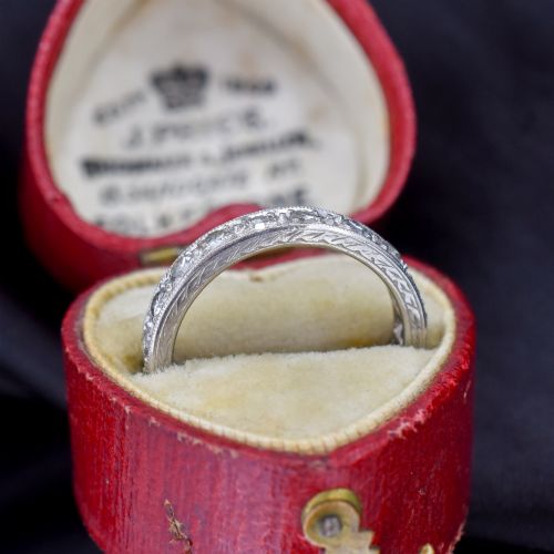 fig 1. An Art Deco palladium full eternity ring set with a continuous band of round diamonds bordered by milgrain edging.